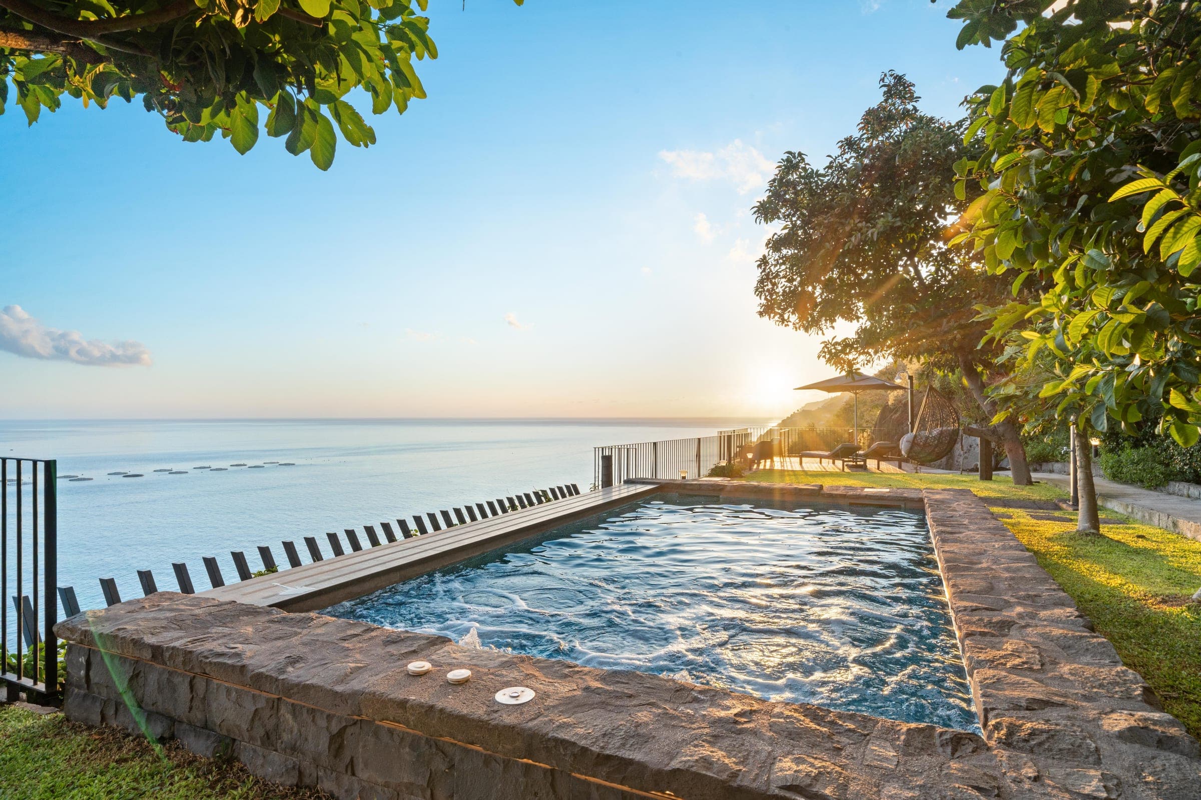 The pool at sunset, the sun dropping into the sea beyond the infinity edge.