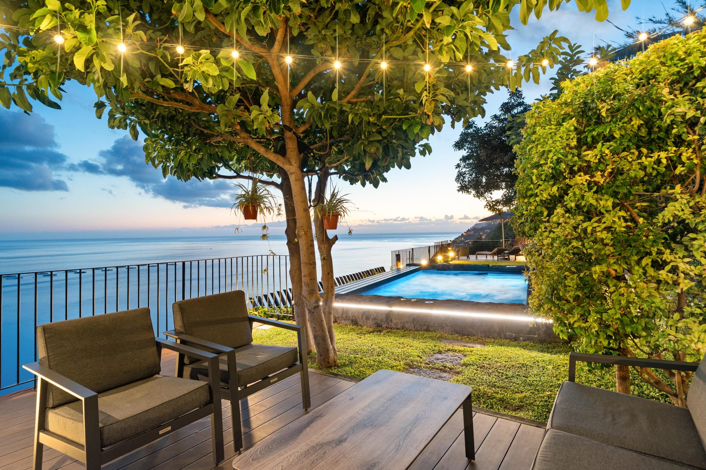 Festoon lights strung through the tree above the terrace sofas.