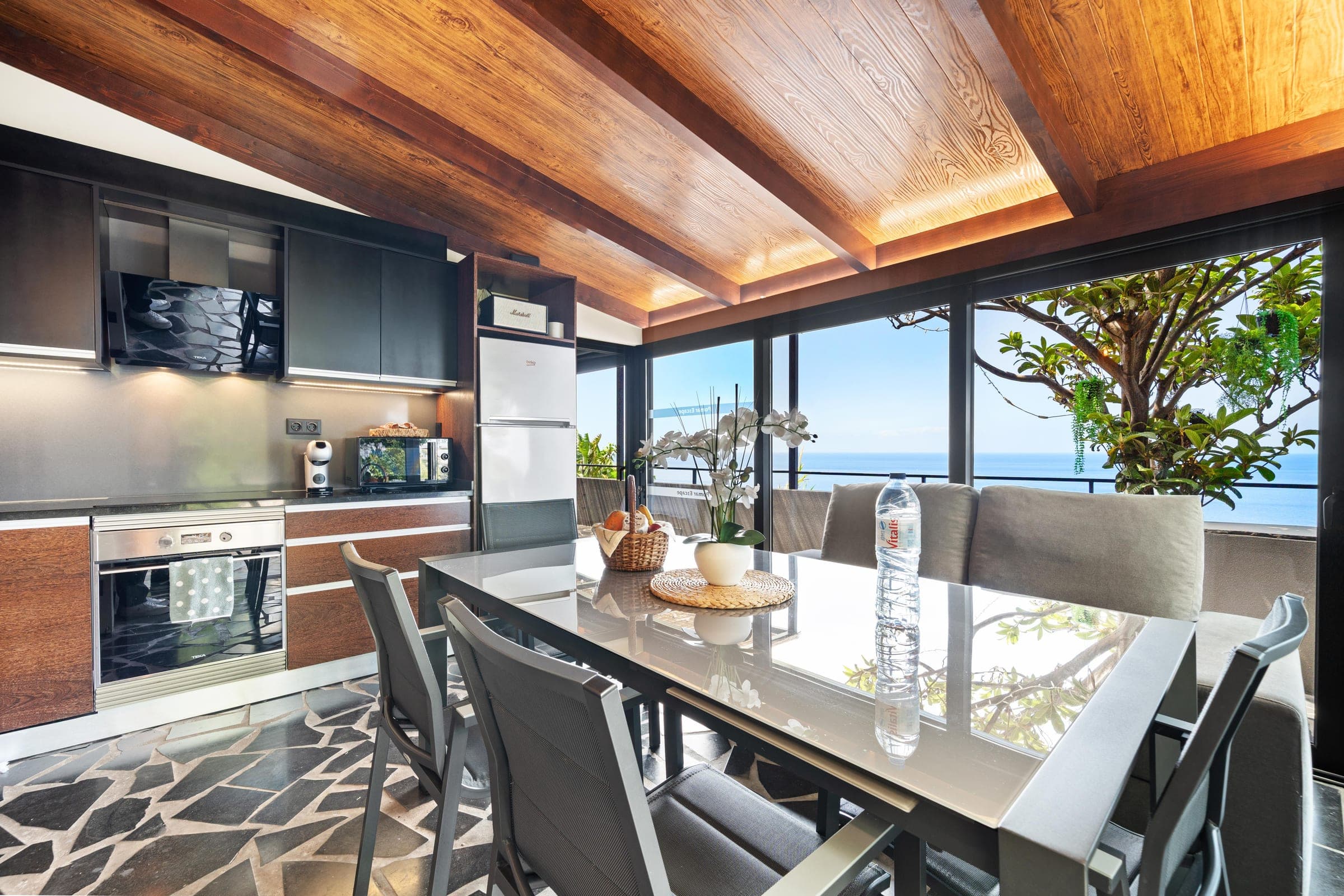 The dining table beside the kitchen, the Atlantic filling the window at the end of the room.