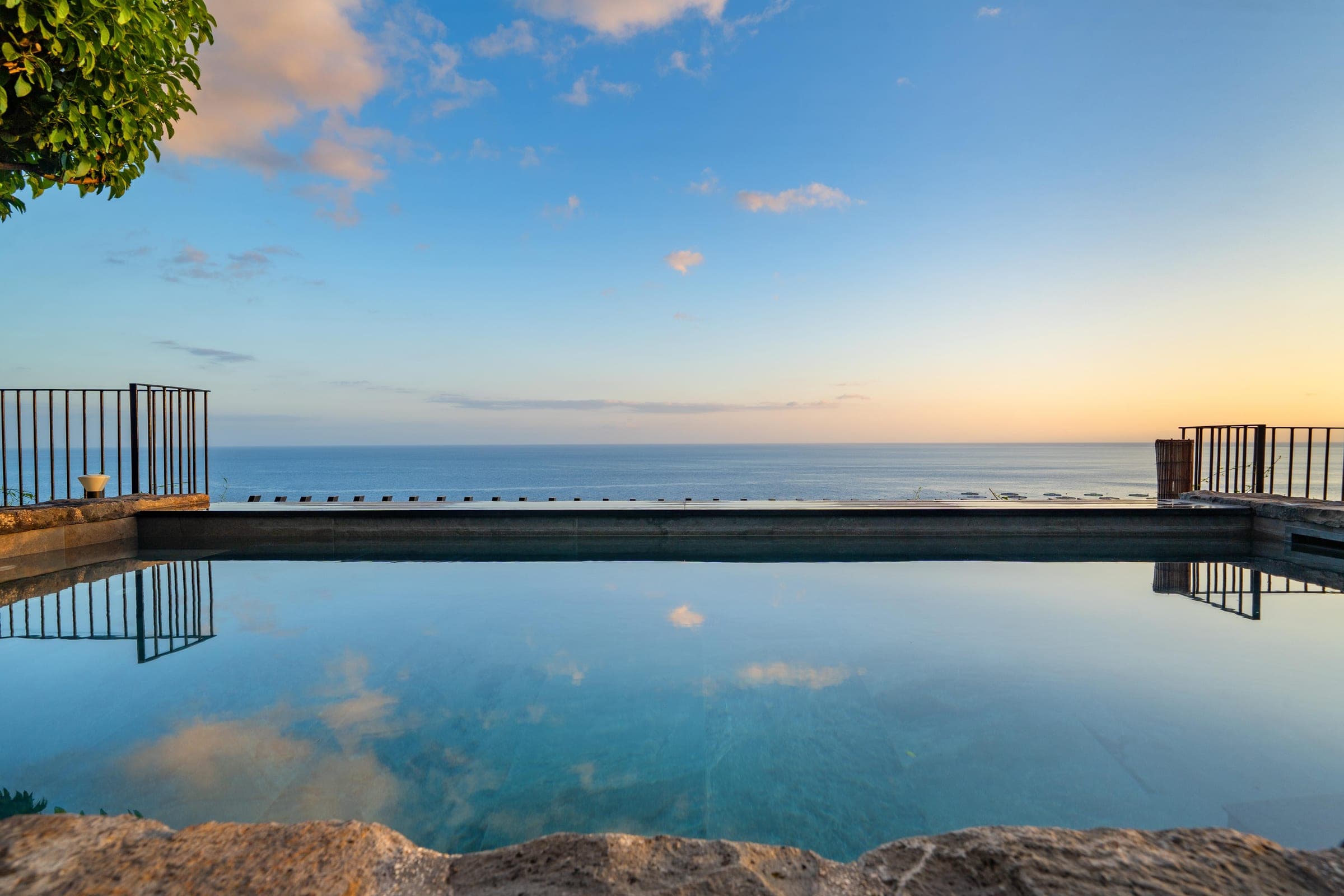 First light: the pool lies mirror-still, its far edge dissolving into the ocean.